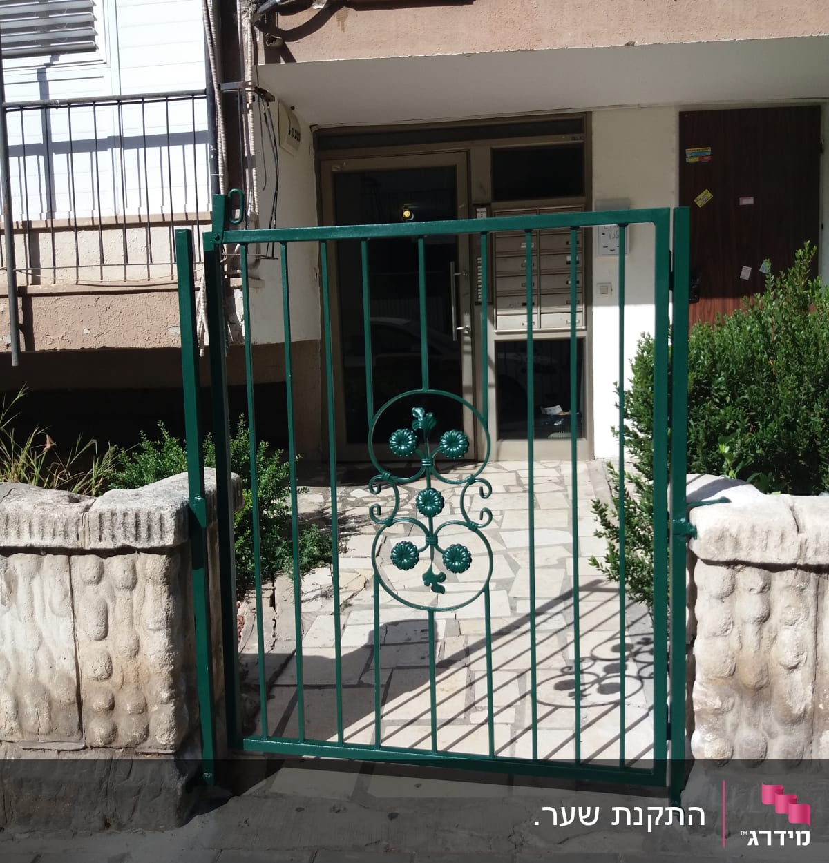 שער מתכת ירוק עם עיטורים פרחוניים